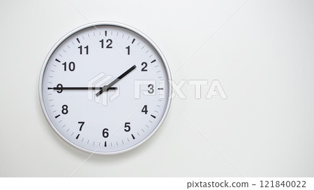 Minimalist White Clock with Silver Frame Striking 13.45/01.45 on White Background. Perfect for Time Management and Corporate Campaigns 121840022
