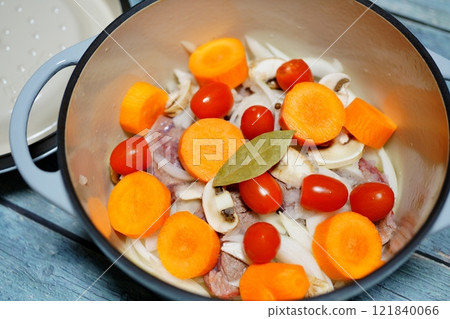 Waterless cooking: Cast iron pot with vegetables and meat 121840066