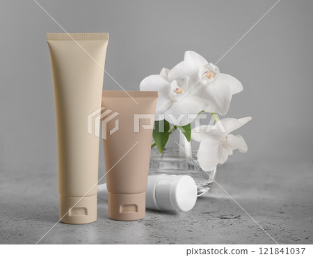 Tubes tonal foundation makeup mockup Featuring Fresh Orchids Set Against a Gray Background Tubes tonal foundation makeup mockup Featuring Fresh Orchids Set Against a Gray Background 121841037