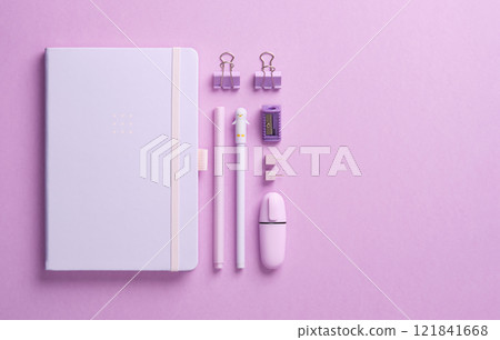 Minimalist pastel stationery flatlay with notepad and office supplies pen, pencil, marker, clips, pins and sharpener on lilac background. Space for your text. Minimalist pastel stationery flatlay with notepad and office supplies pen, pencil, marker, clips, pins and sharpener on lilac background. Space for your text. 121841668