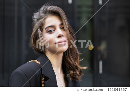 Portrait young woman wearing stylish Black Clothing, beautiful model stands, poses in urban city. Modern high fashion, contemporary street style on Dark Background Portrait young woman wearing stylish Black Clothing, beautiful model stands, poses in urban city. Modern high fashion, contemporary street style on Dark Background 121841867
