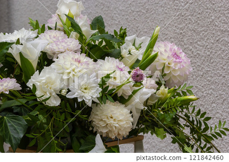 White flower arrangement featuring various blooms in a serene indoor setting 121842460