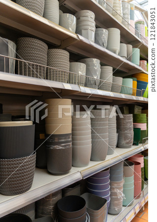 Variety of colorful ceramic and plastic flower pots on the shelf in a plant store. Variety of colorful ceramic and plastic flower pots on the shelf in a plant store. 121843051
