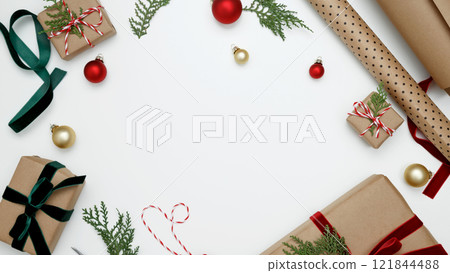 Cozy holiday atmosphere Christmas gifts being wrapped with festive decorations, ribbons, paper 121844488