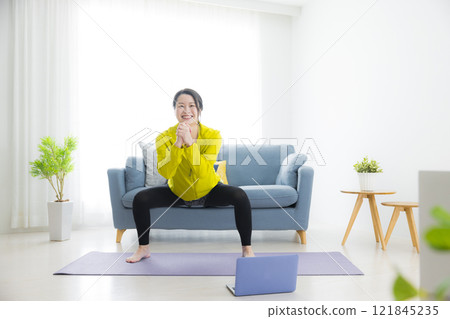 在客廳運動的年輕女子 121845235