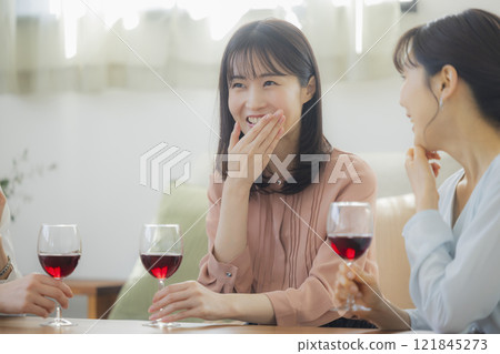 Woman holding a glass of alcohol in the living room Woman holding a glass of alcohol in the living room 121845273