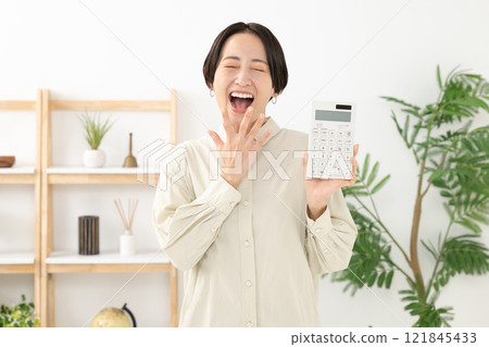 拿著計算器的驚奇的婦女 拿著計算器的驚奇的婦女 121845433