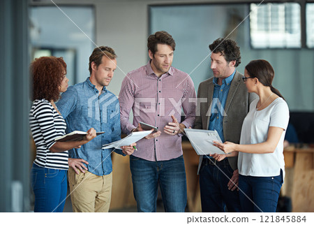Talking, planning or meeting group of colleagues brainstorming ideas, discussing strategy on paperwork and collaboating. Business man explaining reports to a diverse creative marketing team in office Talking, planning or meeting group of colleagues brainstorming ideas, discussing strategy on paperwork and collaboating. Business man explaining reports to a diverse creative marketing team in office 121845884