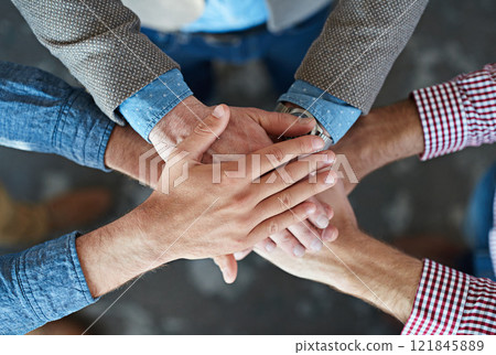 Hands stacked and piled to show team unity, strength and motivation among business men, colleagues and coworkers. Above view, closeup and huddled group of businesspeople in a support and trust circle 121845889