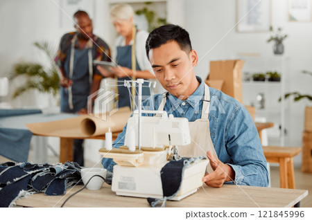 Tailor stitching and making clothes with sewing machine in fashion, design and creative workshop. Serious man working on handmade, trendy and stylish clothing for fashionable boutique or store 121845996