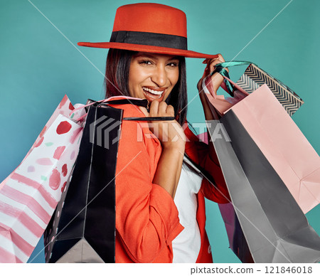 Fun, excited and trendy woman with shopping bags after retail therapy, spending and buying clothes. Portrait of stylish, edgy and funky model holding gifts and wearing colorful, fashionable red suit Fun, excited and trendy woman with shopping bags after retail therapy, spending and buying clothes. Portrait of stylish, edgy and funky model holding gifts and wearing colorful, fashionable red suit 121846018