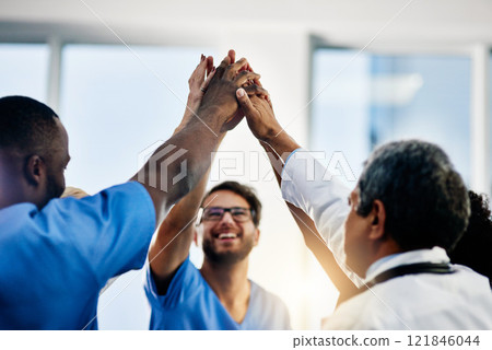 Doctors celebrating medical success after working together as a team and give each other motivating a high five as a group in a hospital. Healthcare workers joining hands in a huddle showing teamwork Doctors celebrating medical success after working together as a team and give each other motivating a high five as a group in a hospital. Healthcare workers joining hands in a huddle showing teamwork 121846044