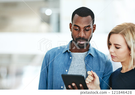 Business people talking together while checking information, data or statistics on a tablet. Employee asking manager, supervisor or boss for help with a problem, project or idea while standing inside Business people talking together while checking information, data or statistics on a tablet. Employee asking manager, supervisor or boss for help with a problem, project or idea while standing inside 121846428