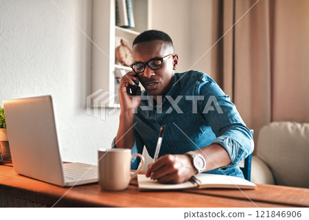 Young serious professional businessman talking on phone call, writing and sitting with digital laptop at home office. African american employee working and consulting in new company startup Young serious professional businessman talking on phone call, writing and sitting with digital laptop at home office. African american employee working and consulting in new company startup 121846906