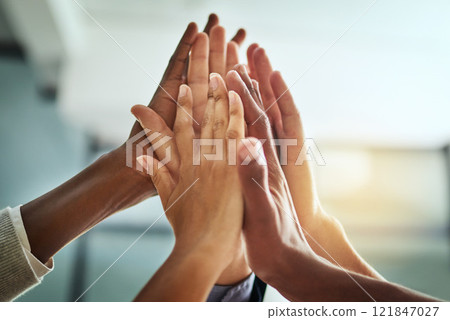 Hands, huddle and high five while a group of diverse businesspeople celebrate and motivate each other at the workplace. Colleagues winning and achieving success through teamwork and collaboration 121847027