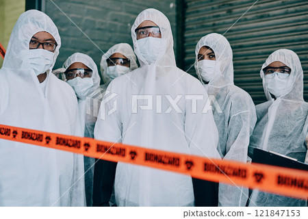 Covid, pandemic and team doctors, scientists or heathcare workers wearing protective ppe to prevent virus spread at a quarantine site. First responders wearing hazmat suits while standing behind tape 121847153