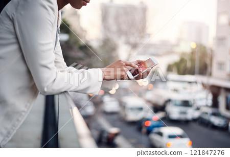 Phone in the hands of a woman for communication, networking and calling while standing on a balcony above a urban city street. Corporate professional taking a break and browsing on a mobile app 121847276