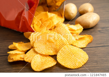 Potato chips, delicious BBQ seasoning spicy for crips, thin slice deep fried snack fast food in open bag. Potato chips, delicious BBQ seasoning spicy for crips, thin slice deep fried snack fast food in open bag. 121847485