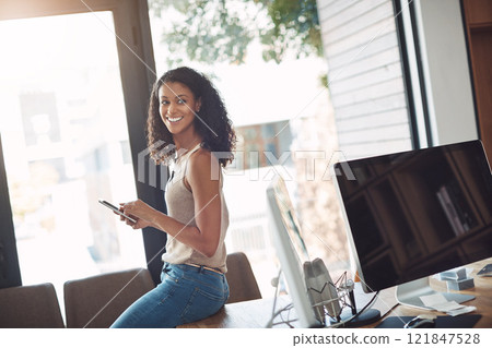 Casual female holding a phone in a home office enjoying working remote sitting on her desk. Candid, real and authentic moment of digital marketing worker. Smiling woman taking a break on social media Casual female holding a phone in a home office enjoying working remote sitting on her desk. Candid, real and authentic moment of digital marketing worker. Smiling woman taking a break on social media 121847528