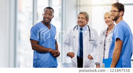 Team of happy doctors having a group discussion about professional healthcare together in a hospital. Friendly young and mature medical workers standing together smiling after a successful treatment Team of happy doctors having a group discussion about professional healthcare together in a hospital. Friendly young and mature medical workers standing together smiling after a successful treatment 121847538