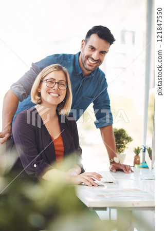 Teamwork between colleagues, coworkers and business partners working together in an office to achieve success. Portrait of two employees looking happy, confident and ready in their design company 121847550