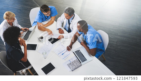 Team of medical workers sitting and meeting with laptops around table. Doctors and staff discussing papers and test results. Healthcare experts handling daily tasks and duties 121847593