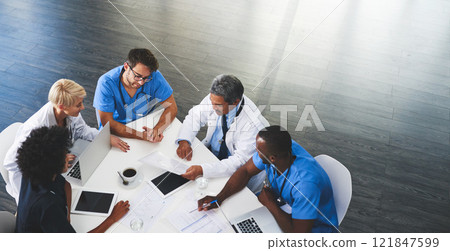 Doctor, nurse and healthcare professional team or group sitting in the boardroom, talking about medicine and discussing treatment during a meeting. Planning and brainstorming a health cure from above Doctor, nurse and healthcare professional team or group sitting in the boardroom, talking about medicine and discussing treatment during a meeting. Planning and brainstorming a health cure from above 121847599