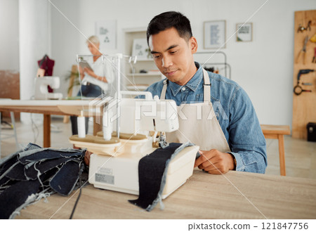 Fashion, design and style with a young designer working in a startup on a sewing machine in a workshop. Busy and creative designer creating new, trendy and fashionable clothes in a small business 121847756