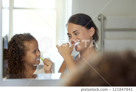 Dental care, brushing teeth and healthy routine in mother and daughter morning at home. Happy, fun and playful child and parent bonding and learning hygiene and grooming with toothpaste in a bathroom 121847841