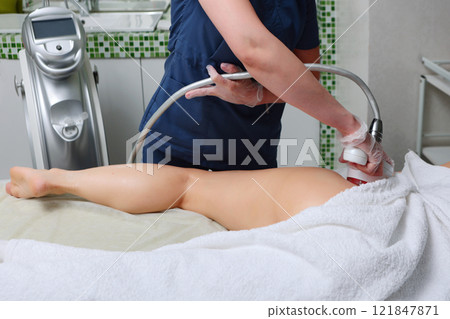 Body care. Anti-cellulite massage of the femoral zone in beauty salon. Hardware cosmetology. Non-surgical correction of figure. Body care. Anti-cellulite massage of the femoral zone in beauty salon. Hardware cosmetology. Non-surgical correction of figure. 121847871