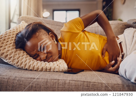 Sad and sick girl with stomach pain, period cramps or menstruation rubbing her belly ache on sofa. One unhappy woman suffering from endometriosis discomfort in abdomen due to PMS and bad healthcare Sad and sick girl with stomach pain, period cramps or menstruation rubbing her belly ache on sofa. One unhappy woman suffering from endometriosis discomfort in abdomen due to PMS and bad healthcare 121847930
