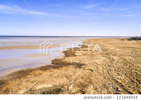 Copy space, blue sky and beach sand on a sea or ocean shore on a private, secluded and quiet island. Landscape view of a calm, serene and peaceful lake or bay with copyspace to relax and enjoy summer Copy space, blue sky and beach sand on a sea or ocean shore on a private, secluded and quiet island. Landscape view of a calm, serene and peaceful lake or bay with copyspace to relax and enjoy summer 121848058