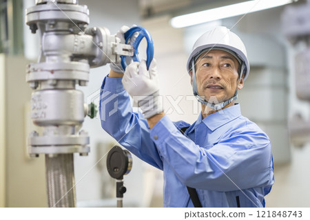 Building maintenance staff image: A worker in his 60s inspecting water supply equipment 121848743
