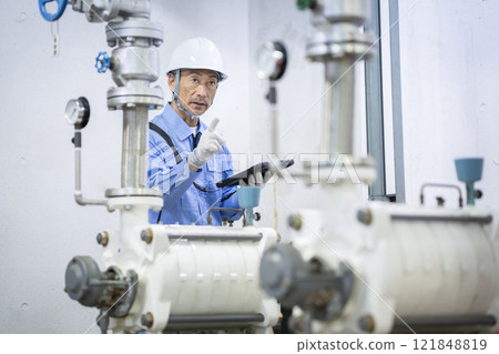 建築維護人員用平板電腦檢查供水設備的圖片 建築維護人員用平板電腦檢查供水設備的圖片 121848819