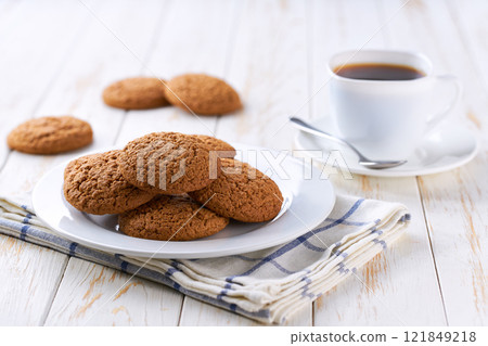 Tasty oatmeal cookies and coffee on a light kitchen table, selective focus. 121849218