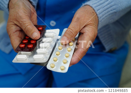 Asian elderly woman holding pill drug in hand, strong healthy medical. 121849885
