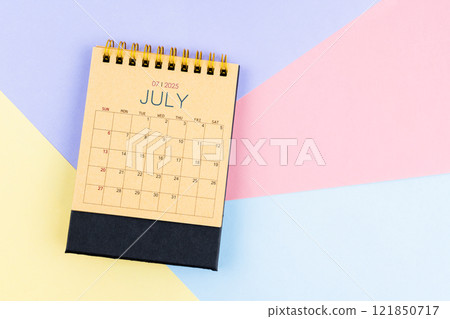 July 2025 desk calendar from brown paper on colorful background. 121850717