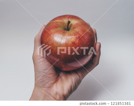 Hand grabbing an apple 121851381