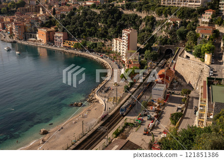 Scenic coastal view near Nice, France with colorful buildings and a passing train, aerial view. French Riviera, Cote d Azur. Mediterranean, travel, and seaside life 121851386