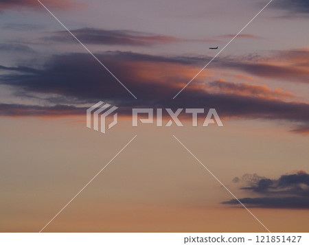 A passenger plane flying towards Haneda in the sunset sky 121851427