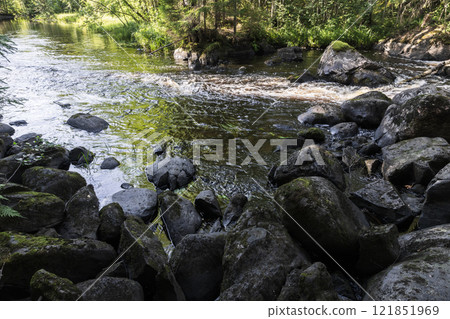 Karelian landscape with wet black rocks at the river coast 121851969