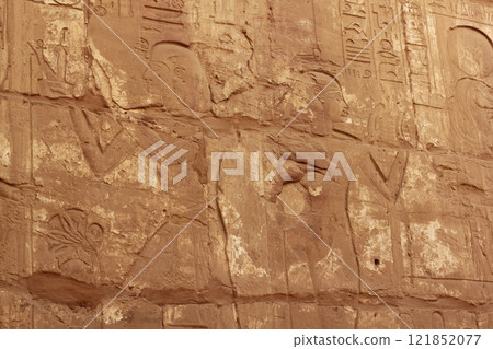Part of the ancient wall at Karnak Temple in Luxor, Egypt. Karnak Temple in Luxor (Egypt) is a massive ancient temple complex. It was dedicated to the god Amun-Ra and his wife Mut 121852077