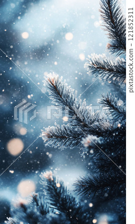 Spruce branches in the foreground with a blurred snowy forest and gentle snowfall in the background, creating a serene winter scene 121852311