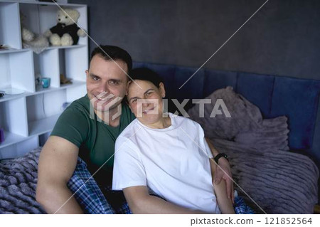 a senior woman and young man hugging on bed 121852564