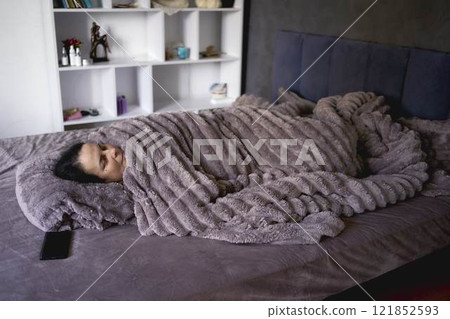 a senior woman sleeping under a weighted blanket 121852593