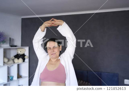 a senior woman in underwear stretching, resting, enjoying life on bed at home 121852613