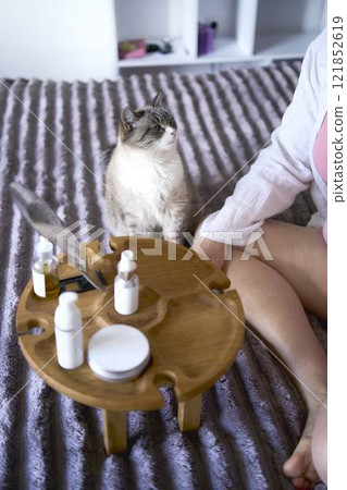 a senior woman in underwear on the bed performs routine self-care with face and body cosmetics a senior woman in underwear on the bed performs routine self-care with face and body cosmetics 121852619