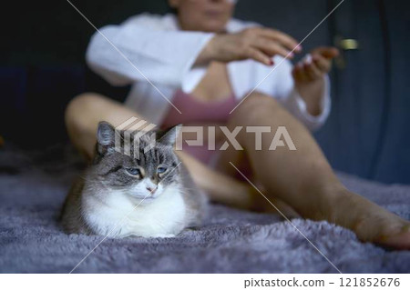 a senior woman in underwear on the bed performs routine self-care with body cosmetics a senior woman in underwear on the bed performs routine self-care with body cosmetics 121852676