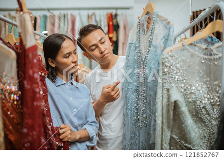 A Couple Selecting Stylish and Elegant Dresses at the Fashion Boutique Today 121852767