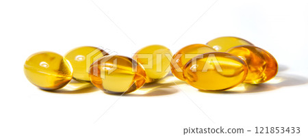 Golden Gelatin Capsules Arranged on a Clean White Surface Showcasing Their Smooth Texture Golden Gelatin Capsules Arranged on a Clean White Surface Showcasing Their Smooth Texture 121853433